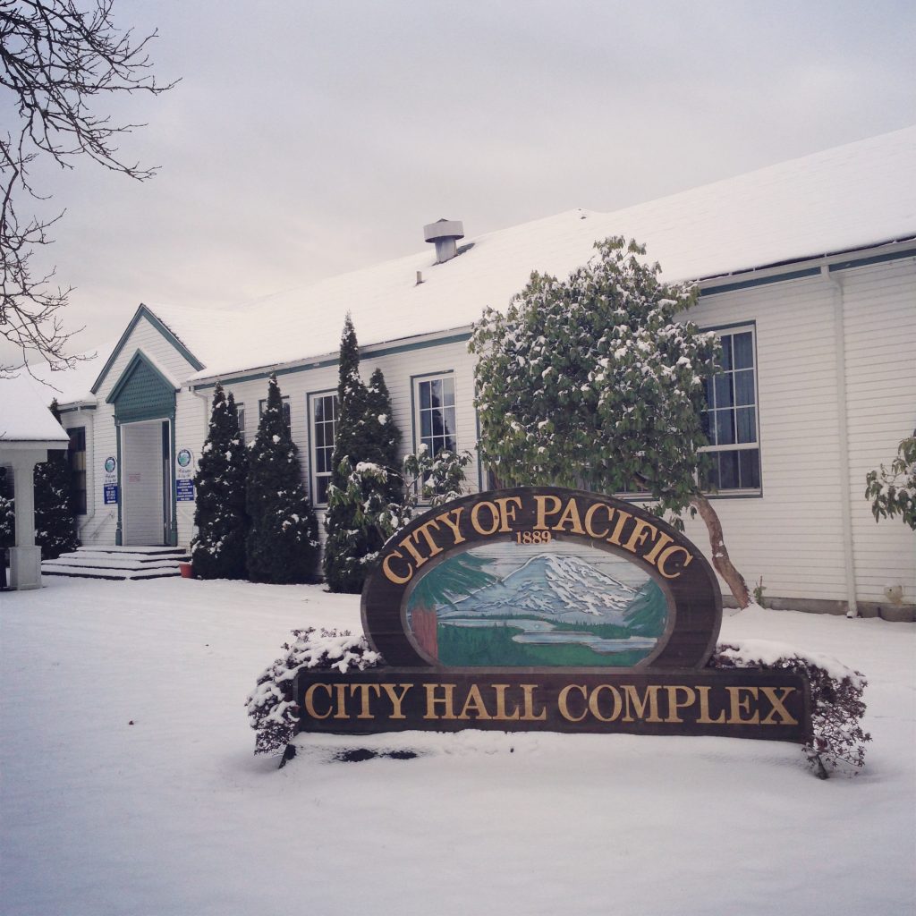 City of Pacific Hall Complex building in winter with snow-covered ground and sign